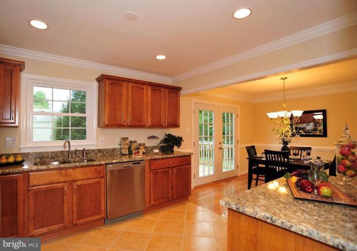 6806 Ben Franklin Road Springfield, VA 22150 - Photo 12 of 21 a kitchen with stainless steel appliances granite countertop sink stove and wooden cabinets