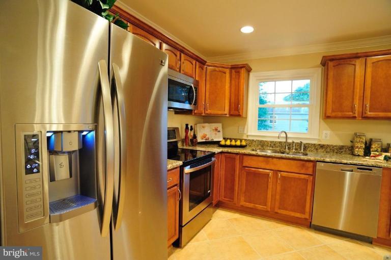 6806 Ben Franklin Road Springfield, VA 22150 - Photo 13 of 21 a kitchen with stainless steel appliances granite countertop a refrigerator a stove top oven and a sink