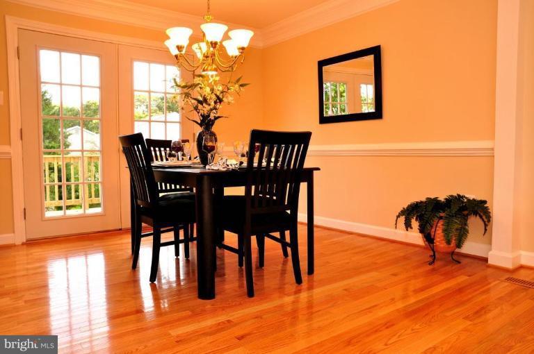 6806 Ben Franklin Road Springfield, VA 22150 - Photo 14 of 21 a dining room with furniture a floor to ceiling window and wooden floor