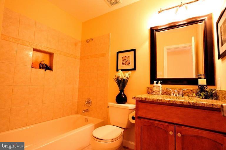 6806 Ben Franklin Road Springfield, VA 22150 - Photo 21 of 21 a bathroom with a granite countertop sink toilet and mirror