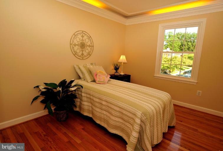 6806 Ben Franklin Road Springfield, VA 22150 - Photo 8 of 21 a bedroom with a bed and a chandelier