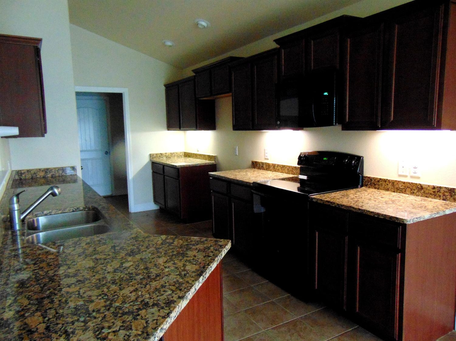 9708 Remington Avenue Lubbock, TX 79424 - Photo 9 of 10 a kitchen with a sink stove and cabinets