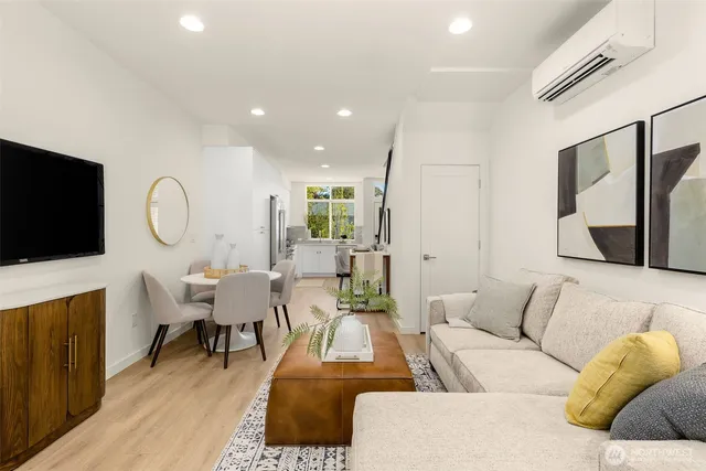 a living room with furniture a flat screen tv and kitchen view