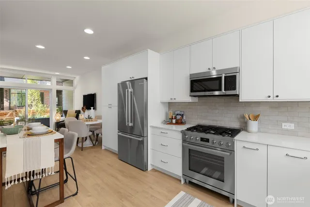 a kitchen with stainless steel appliances a stove microwave and refrigerator