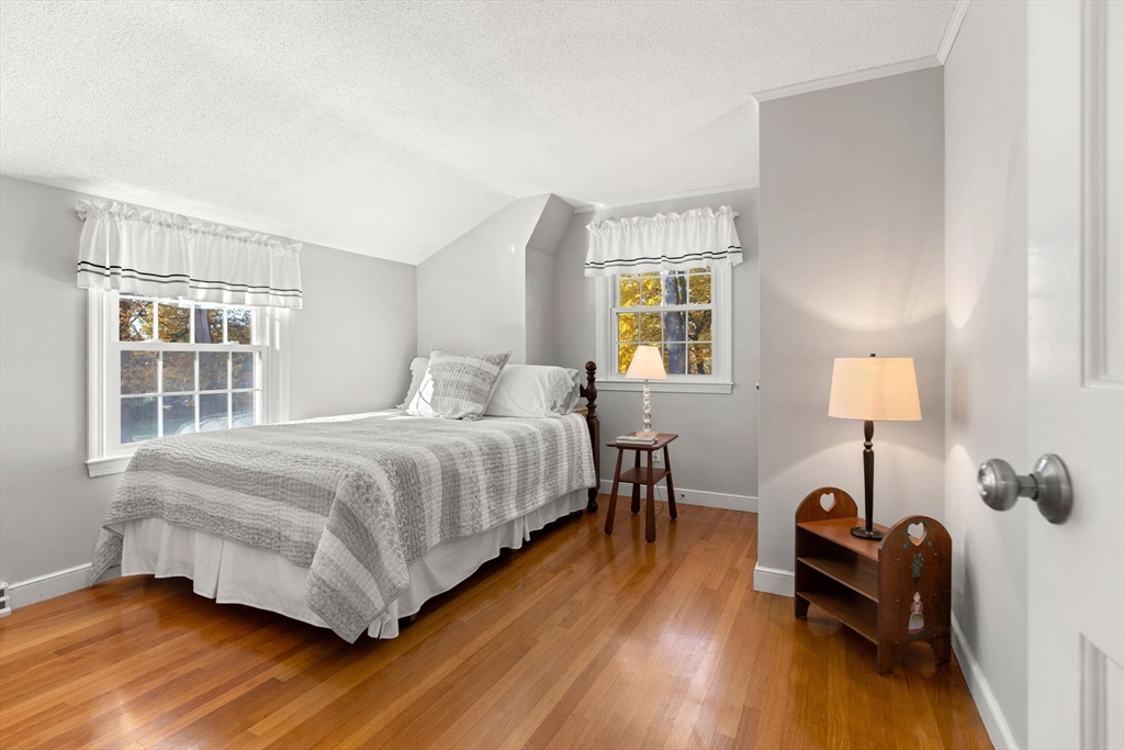 5 Fulton Road Andover, MA 01810 - Photo 19 of 27 a bedroom with a bed and a lamp on dresser with wooden floor
