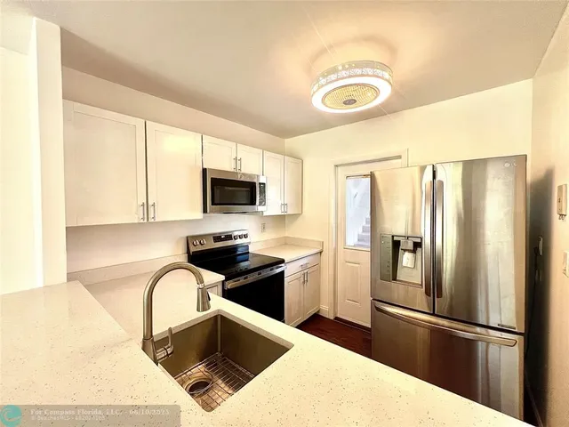 a kitchen with stainless steel appliances granite countertop a refrigerator a stove top oven a sink and dishwasher
