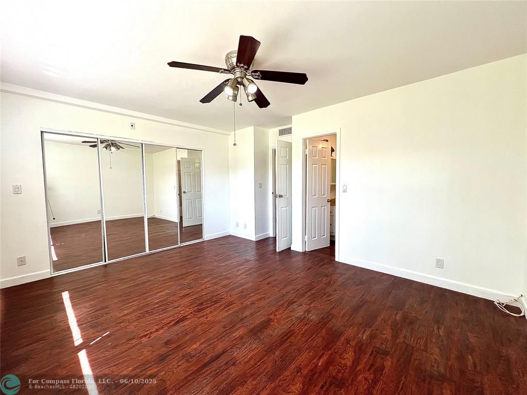 5001 West Oakland Park Boulevard, Unit 111 Lauderdale Lakes, FL 33313 - Photo 21 of 38 a view of empty room with wooden floor and fan