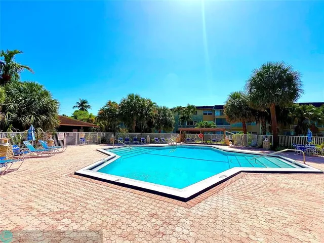 a view of a backyard with swimming pool and furniture