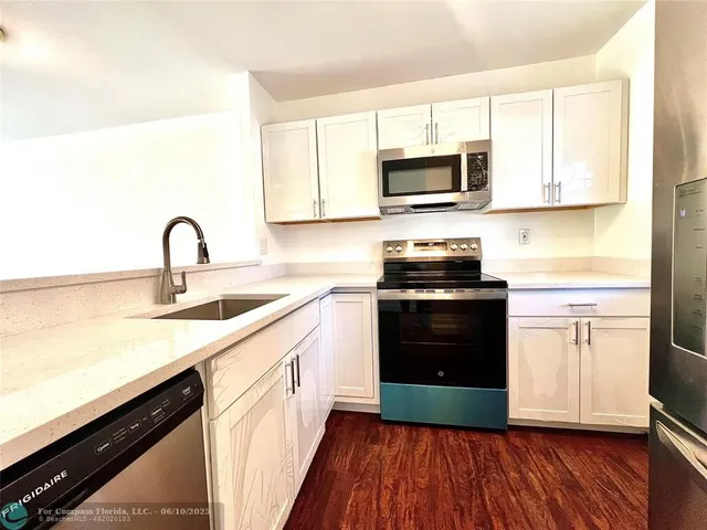 a kitchen with granite countertop a sink and steel appliances