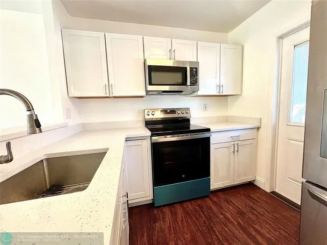 a kitchen with granite countertop a sink and a stove top oven