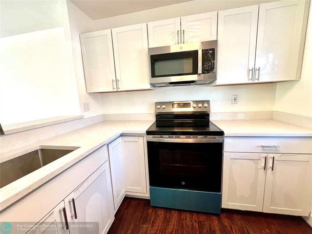 5001 West Oakland Park Boulevard, Unit 111 Lauderdale Lakes, FL 33313 - Photo 5 of 38 a kitchen with a stove and a microwave
