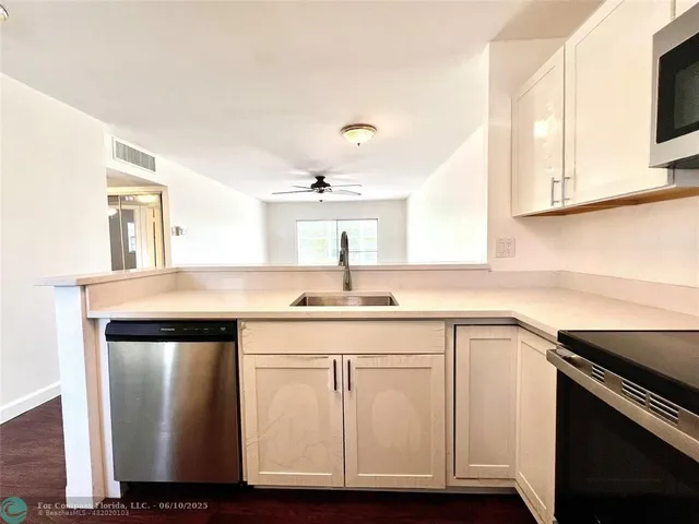 a kitchen with cabinets appliances and a sink