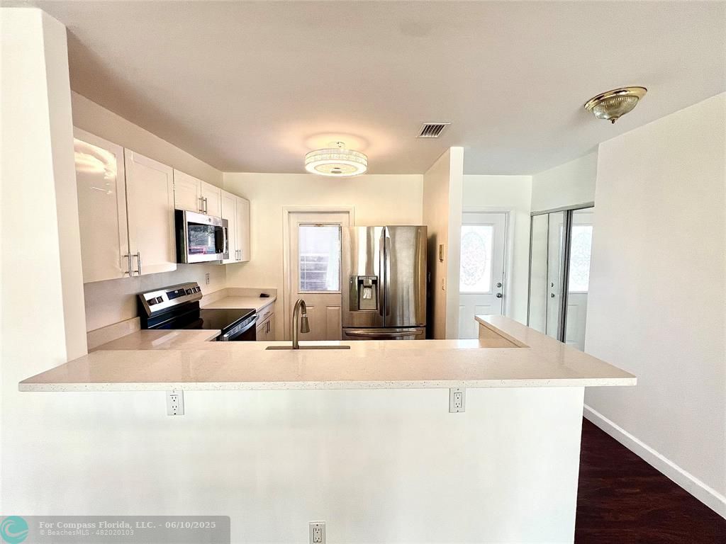 5001 West Oakland Park Boulevard, Unit 111 Lauderdale Lakes, FL 33313 - Photo 7 of 38 a view of a kitchen with kitchen island a sink stainless steel appliances and cabinets