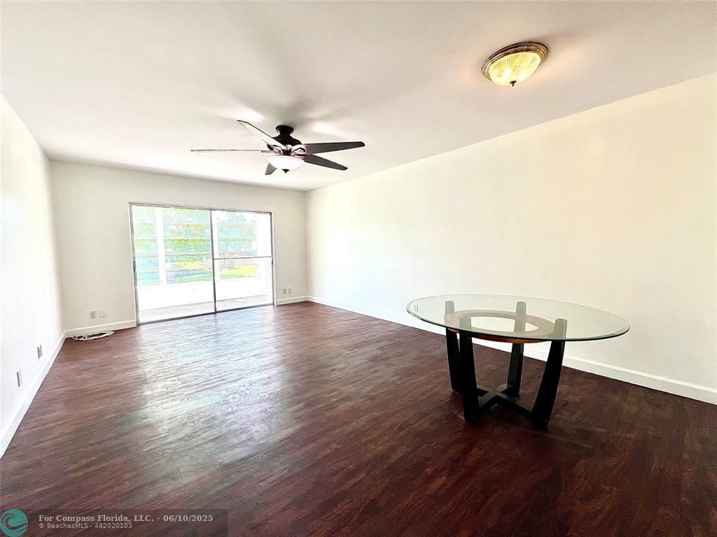 5001 West Oakland Park Boulevard, Unit 111 Lauderdale Lakes, FL 33313 - Photo 8 of 38 a view of an empty room with a window and wooden floor