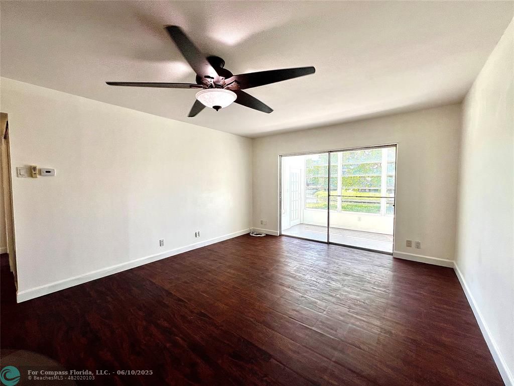 5001 West Oakland Park Boulevard, Unit 111 Lauderdale Lakes, FL 33313 - Photo 10 of 38 an empty room with wooden floor fan and windows