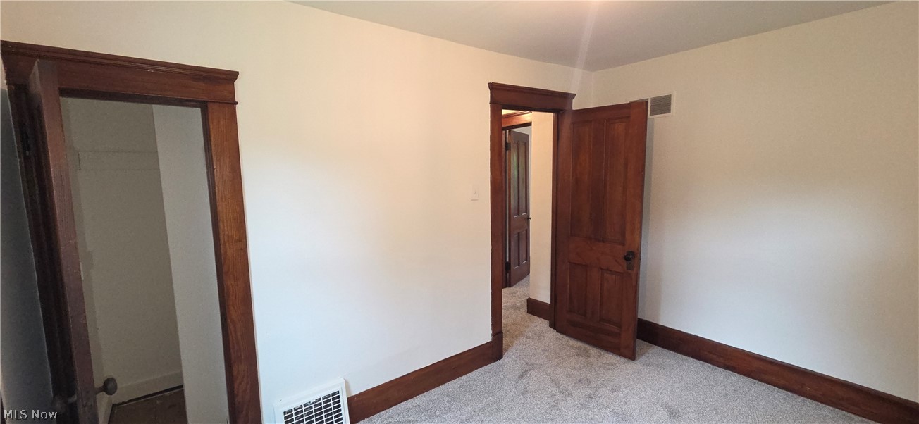 9964 East River Road Elyria, OH 44035 - Photo 25 of 45 Bedroom 2 featuring light-colored walls, wood-finish trim, and gray carpet flooring