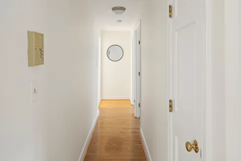a view of a hallway with closet and wooden floor