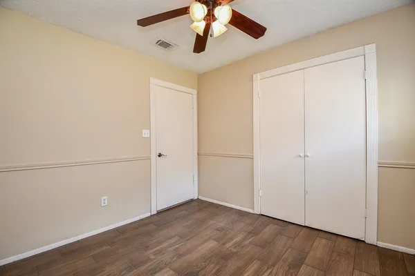 a view of an empty room and chandelier fan