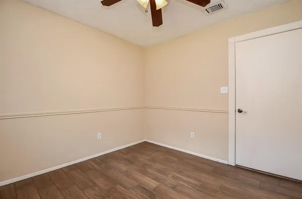 an empty room and chandelier fan