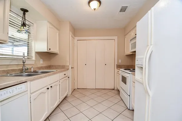 a kitchen with granite countertop white cabinets and white appliances