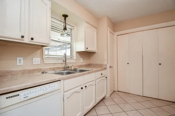 a kitchen with white cabinets and white appliances