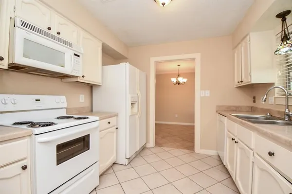 a kitchen with granite countertop white cabinets and white appliances