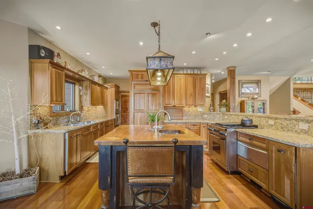 a kitchen with granite countertop a sink stove and refrigerator
