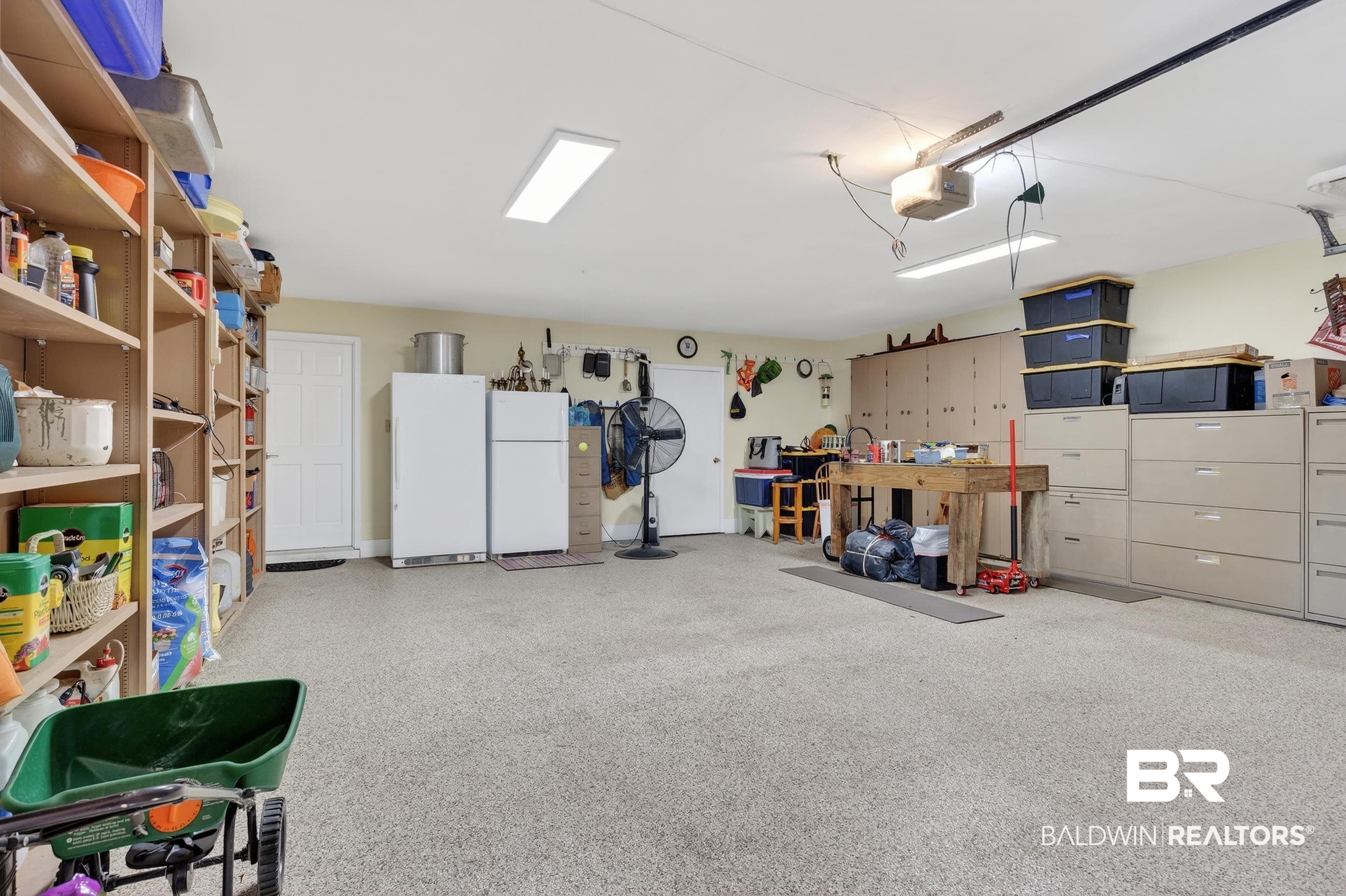 1271 Spring Valley Drive South Mobile, AL 36693 - Photo 54 of 56 Garage featuring freestanding refrigerator, a workshop area, and a garage door opener