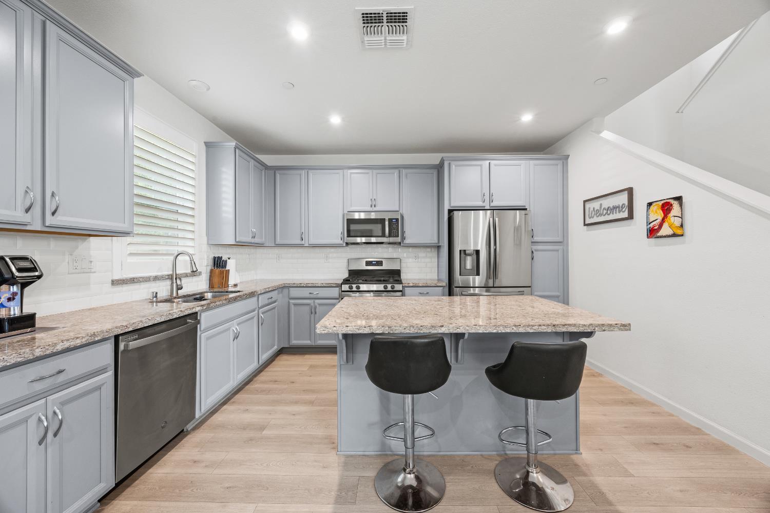 1048 Knox Way Roseville, CA 95747 - Photo 12 of 29 a kitchen with stainless steel appliances granite countertop a sink a stove a refrigerator cabinets and chairs
