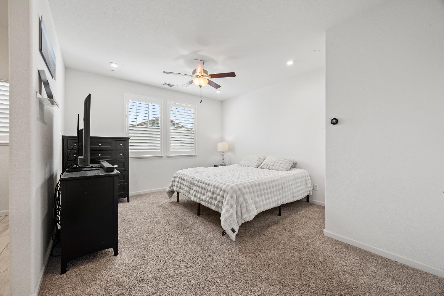 1048 Knox Way Roseville, CA 95747 - Photo 22 of 29 a spacious bedroom with a bed and a chandelier