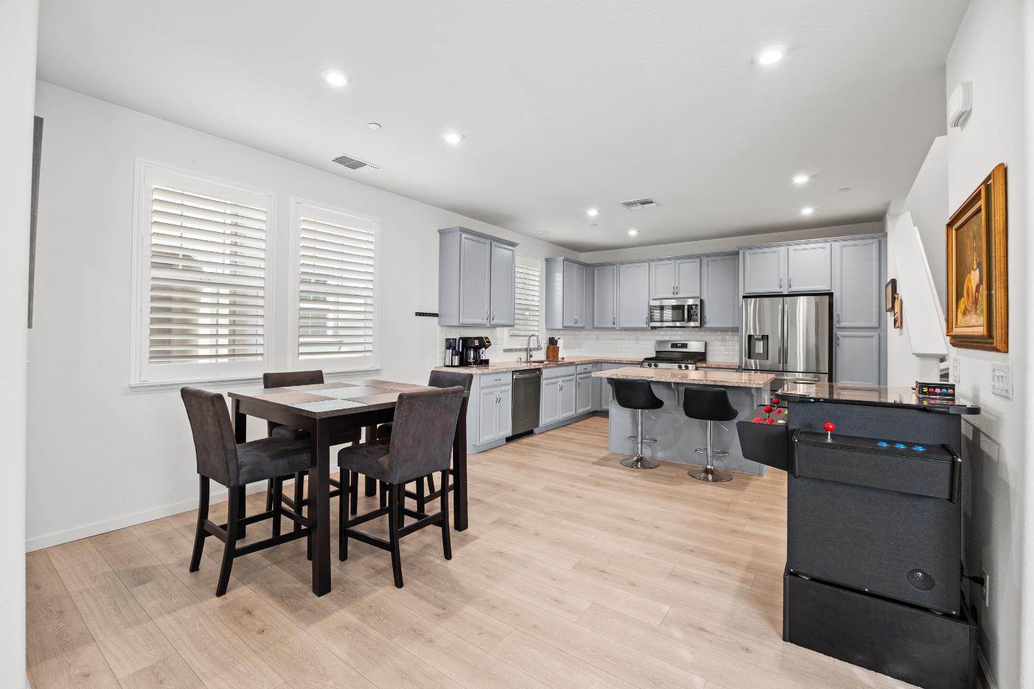 1048 Knox Way Roseville, CA 95747 - Photo 8 of 29 a kitchen with stainless steel appliances kitchen island granite countertop a table chairs sink refrigerator and cabinets