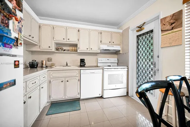 a kitchen with white cabinets and white appliances
