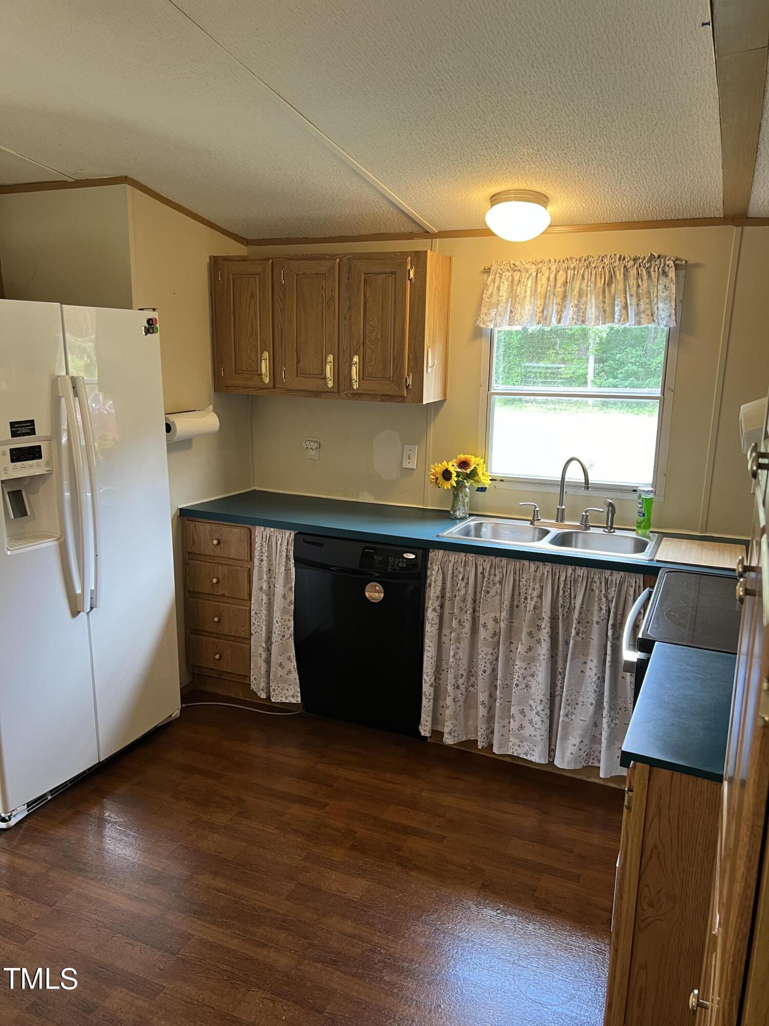 7729 Strickland Road Bailey, NC 27807 - Photo 4 of 8 a kitchen with stainless steel appliances wooden cabinets a refrigerator a sink and a stove