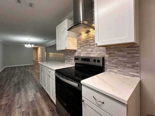 a kitchen with a stove and a wooden floor