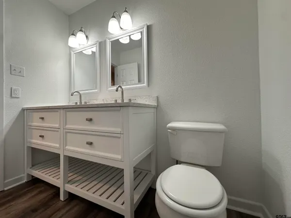 a bathroom with a granite countertop sink a toilet and shower