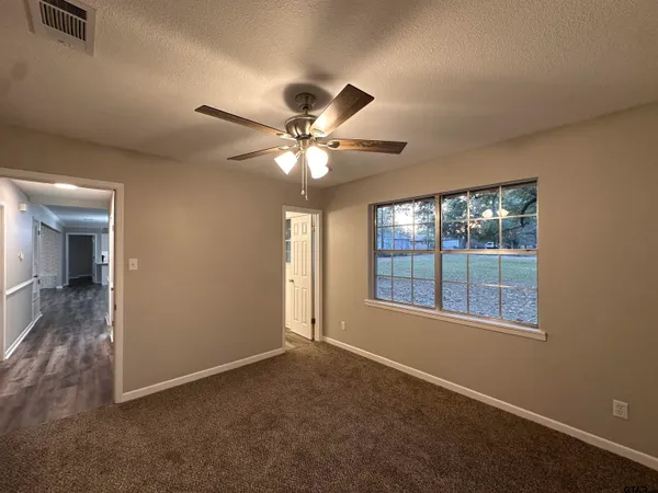 an empty room with a window and a fan