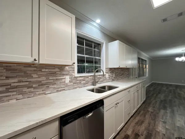 a kitchen with a stove and a wooden floor