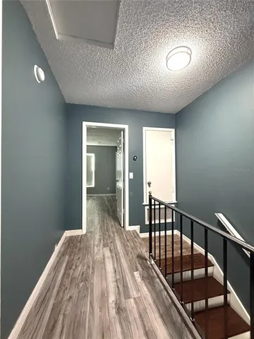 a view of a hallway with wooden floor and stairs
