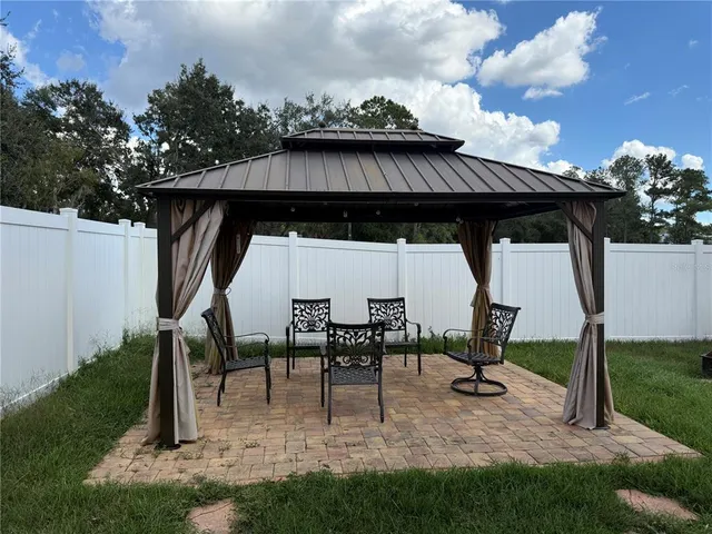 a view of backyard with table and chairs