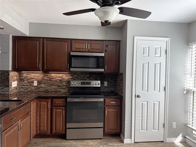 a kitchen with stainless steel appliances granite countertop a stove and a microwave