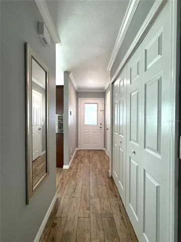 a view of a hallway with wooden floor and glass door