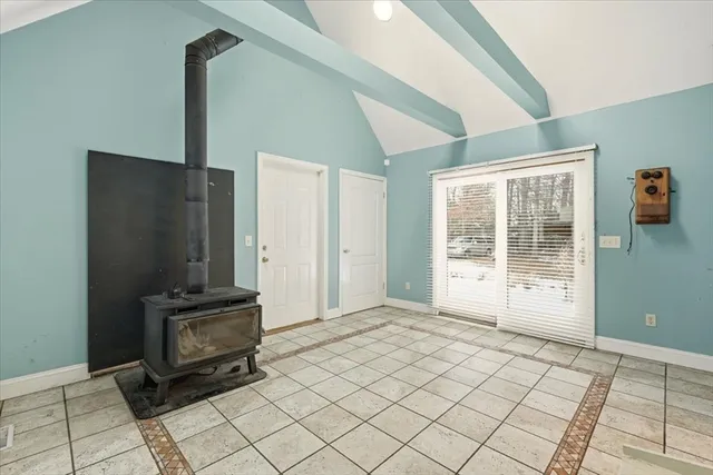 a view of an empty room with a fireplace and a window