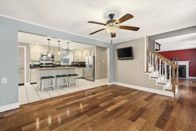 a living room with stainless steel appliances kitchen island granite countertop furniture and a flat screen tv