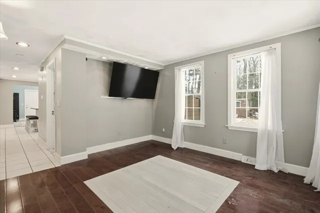 a view of a livingroom with wooden floor and a flat screen tv