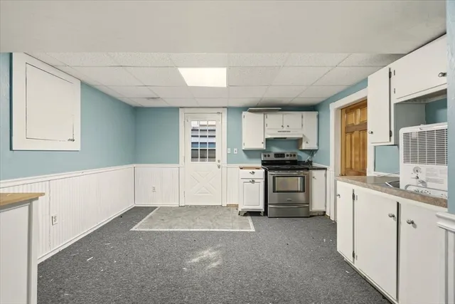 a kitchen with granite countertop a stove a sink and a microwave