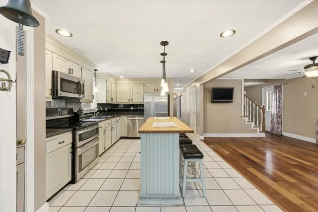 a large kitchen with cabinets stove top oven and sink