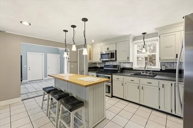 a kitchen with stainless steel appliances a sink a stove a refrigerator and cabinets