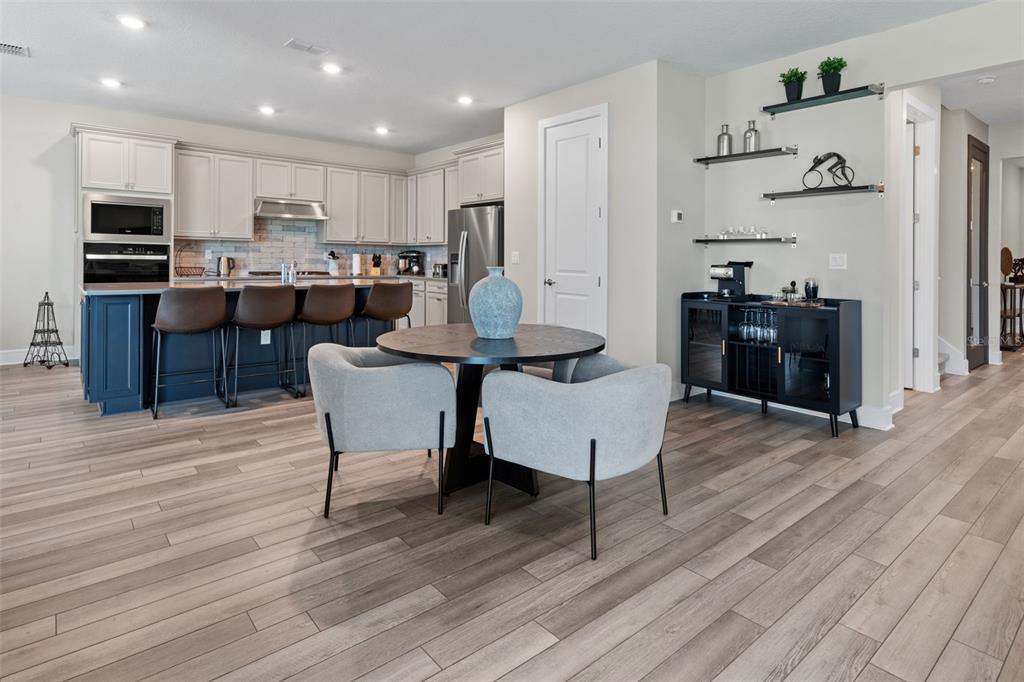 15203 Willow Ridge Drive Montverde, FL 34756 - Photo 19 of 51 a kitchen with stainless steel appliances kitchen island granite countertop a table chairs sink and cabinets