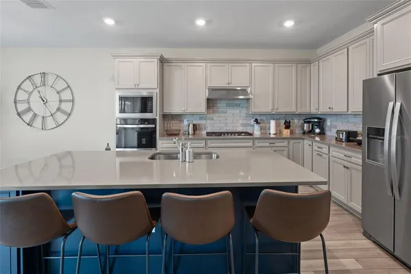 a kitchen with stainless steel appliances granite countertop a table chairs stove microwave and cabinets