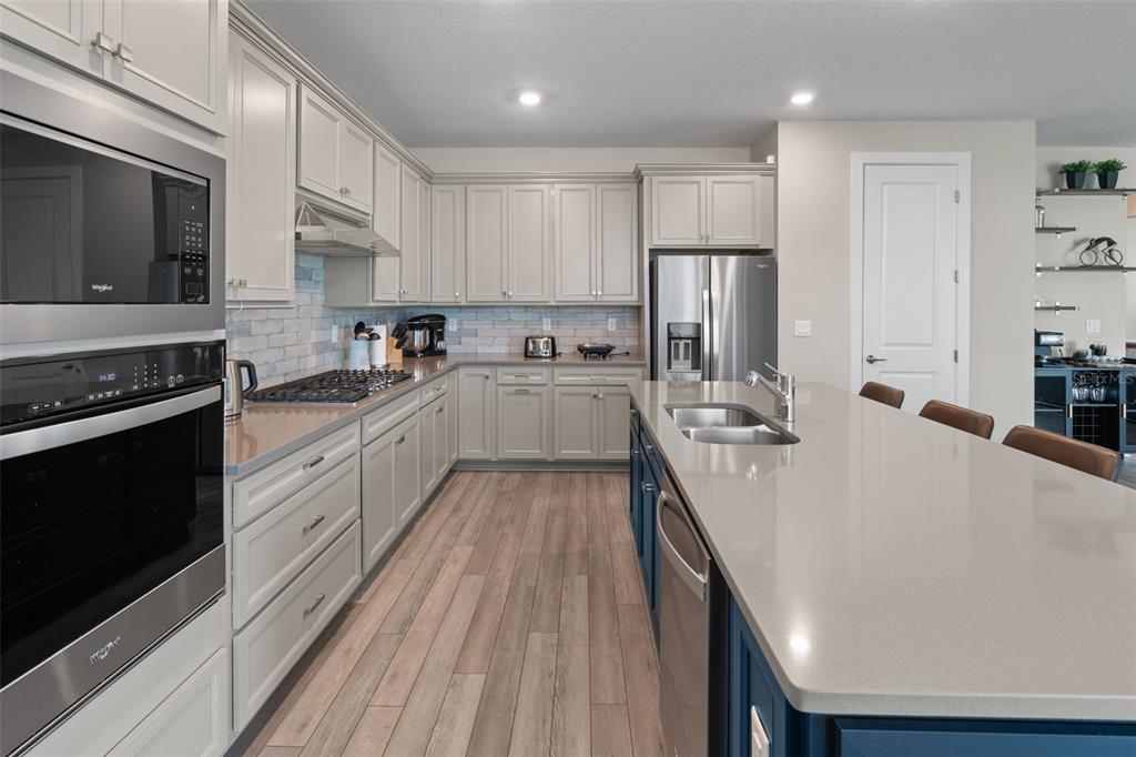 15203 Willow Ridge Drive Montverde, FL 34756 - Photo 26 of 51 a large kitchen with a stove a sink dishwasher a refrigerator and wooden cabinets with wooden floor